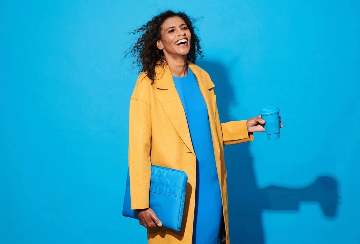 Lady with a blue coffee mug and a yellow coat