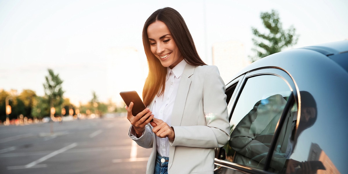 Woman on phone leaning against car