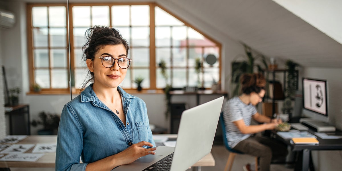 Woman in eyeglasses holding laptop