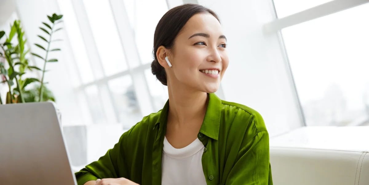 Asian women in brightly lit room, wearing green shirt