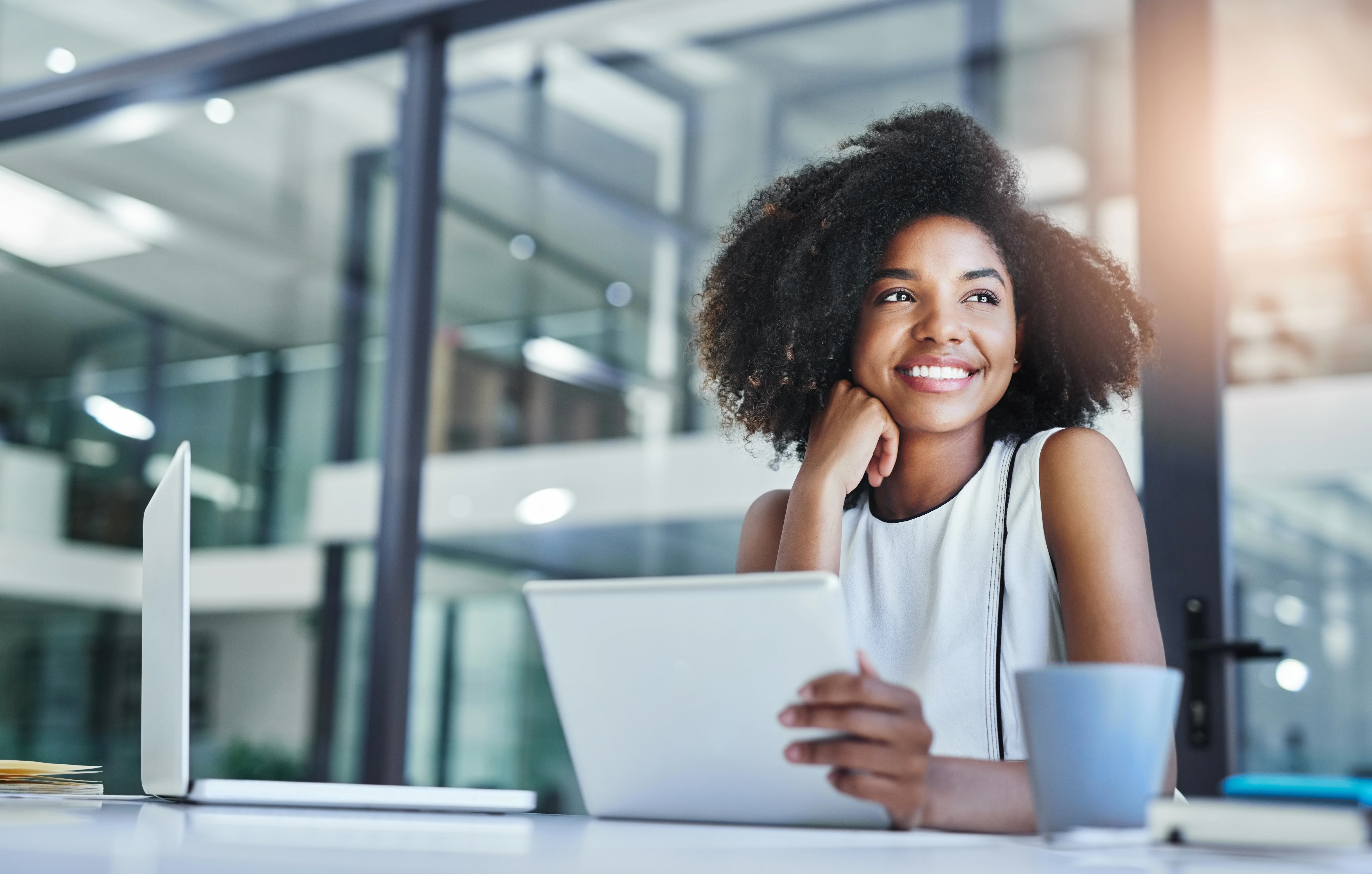 Smiling woman holding tablet in an office