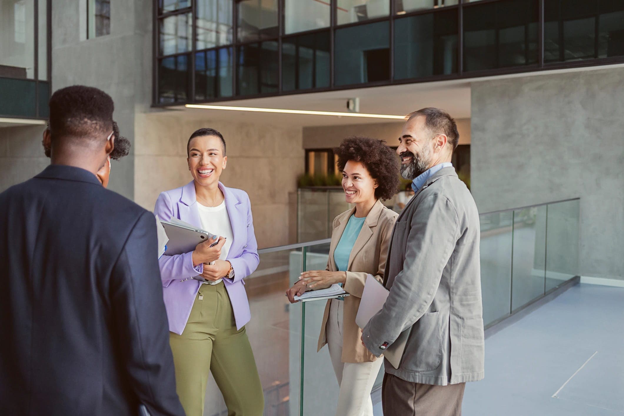 Four people smiling and chatting in an office