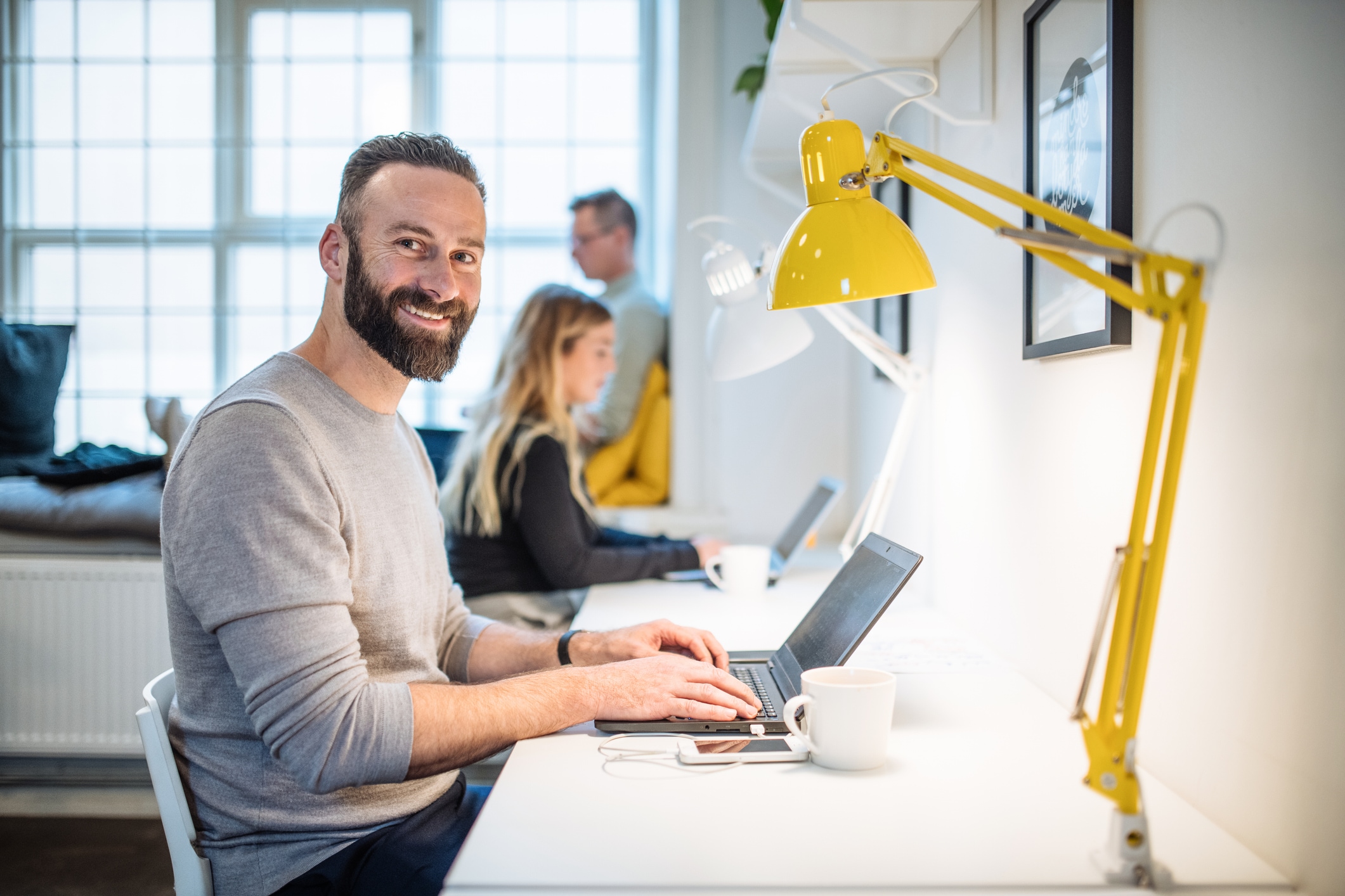 team working at desk with man looking at camera