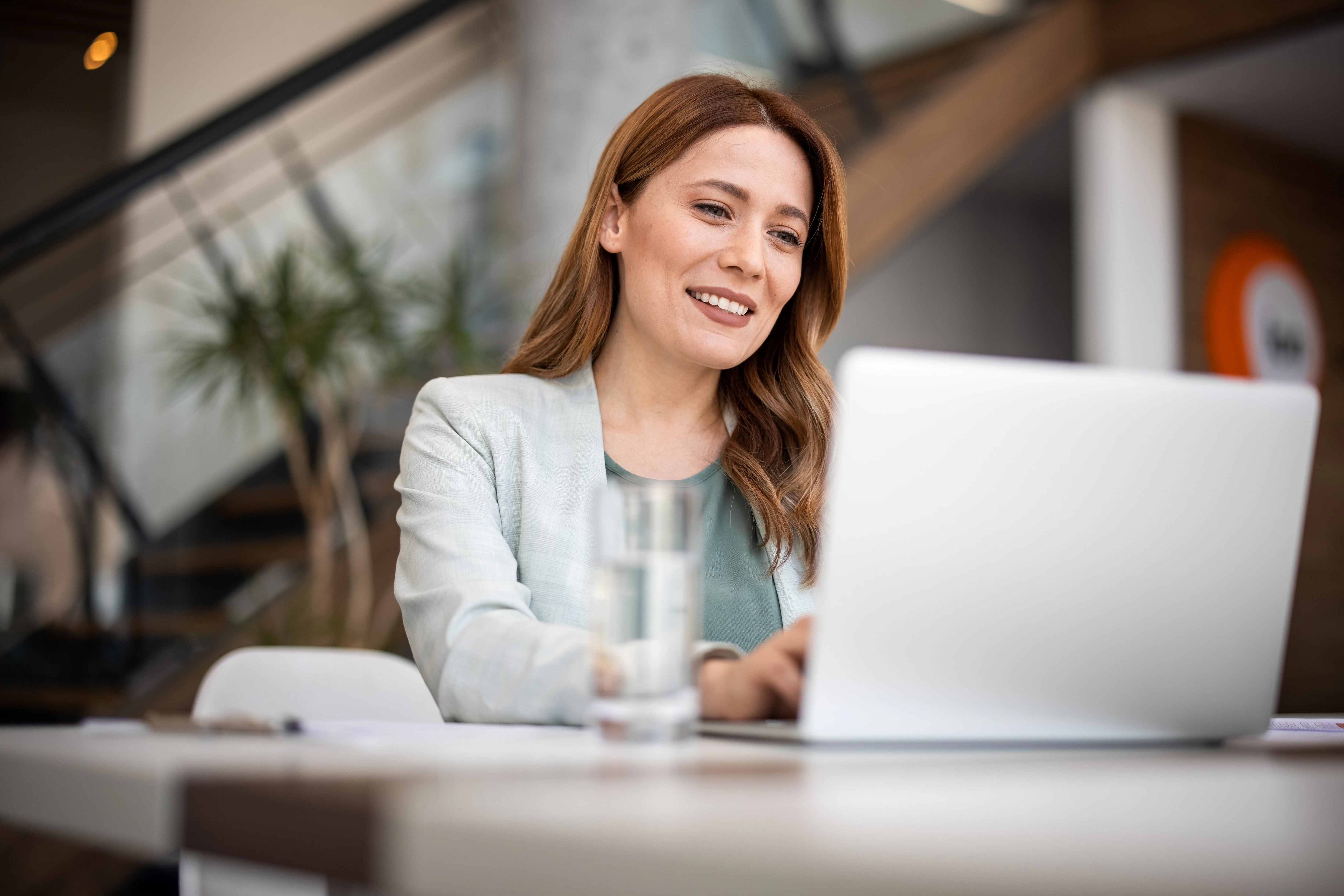 Woman working on laptop, smiling