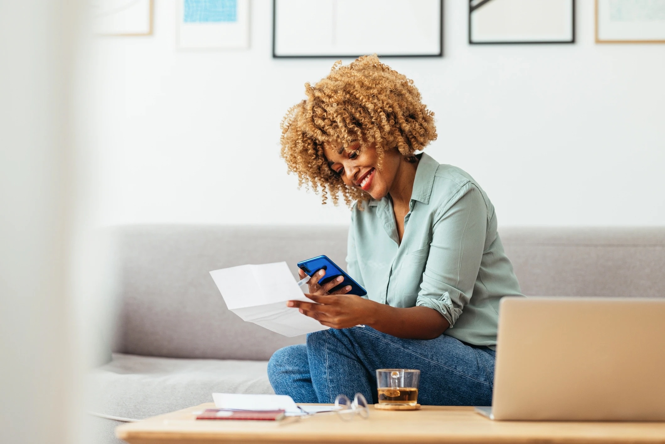 Woman sitting on couch looking at a paper
