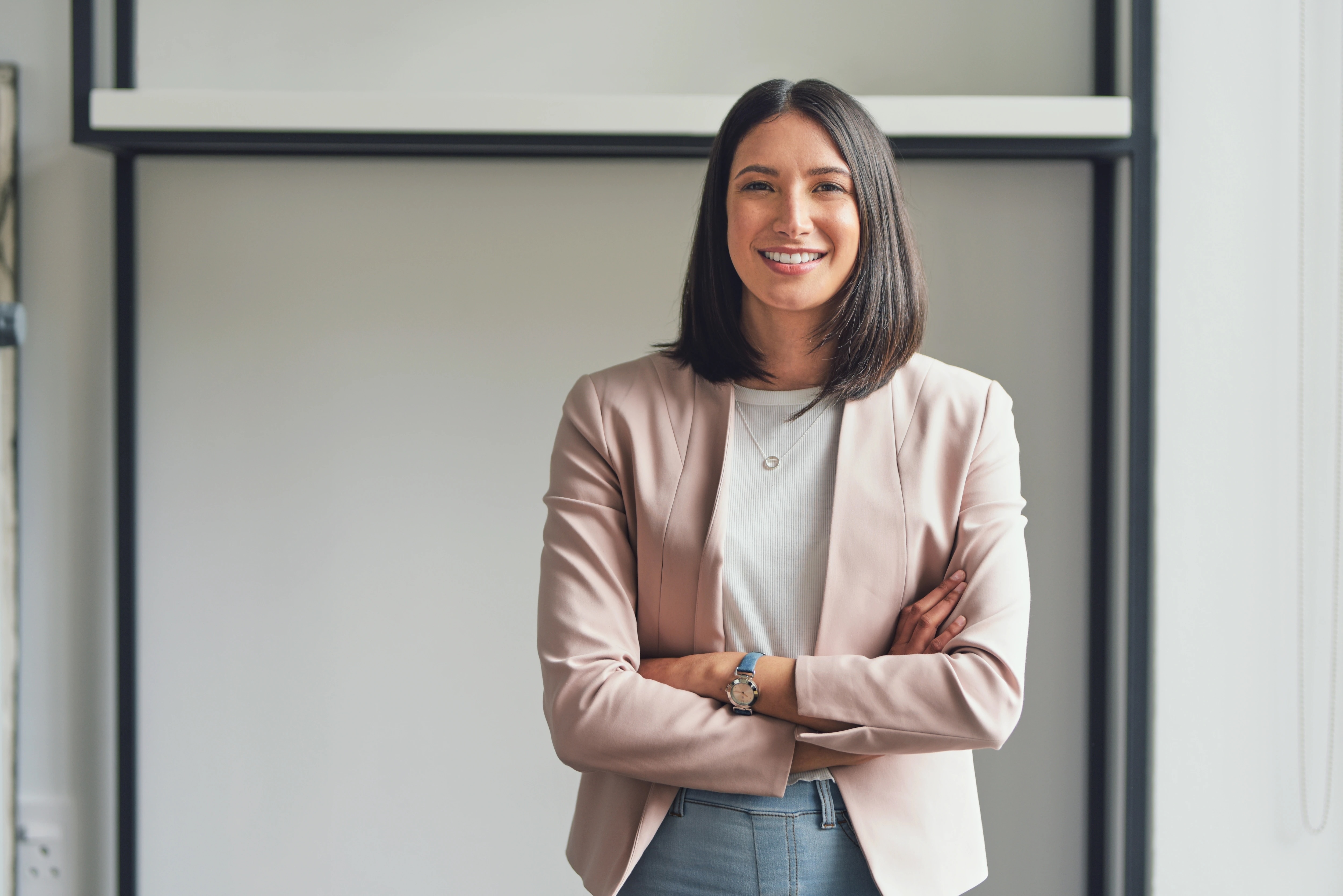 Woman in pink blazer with arms crossed