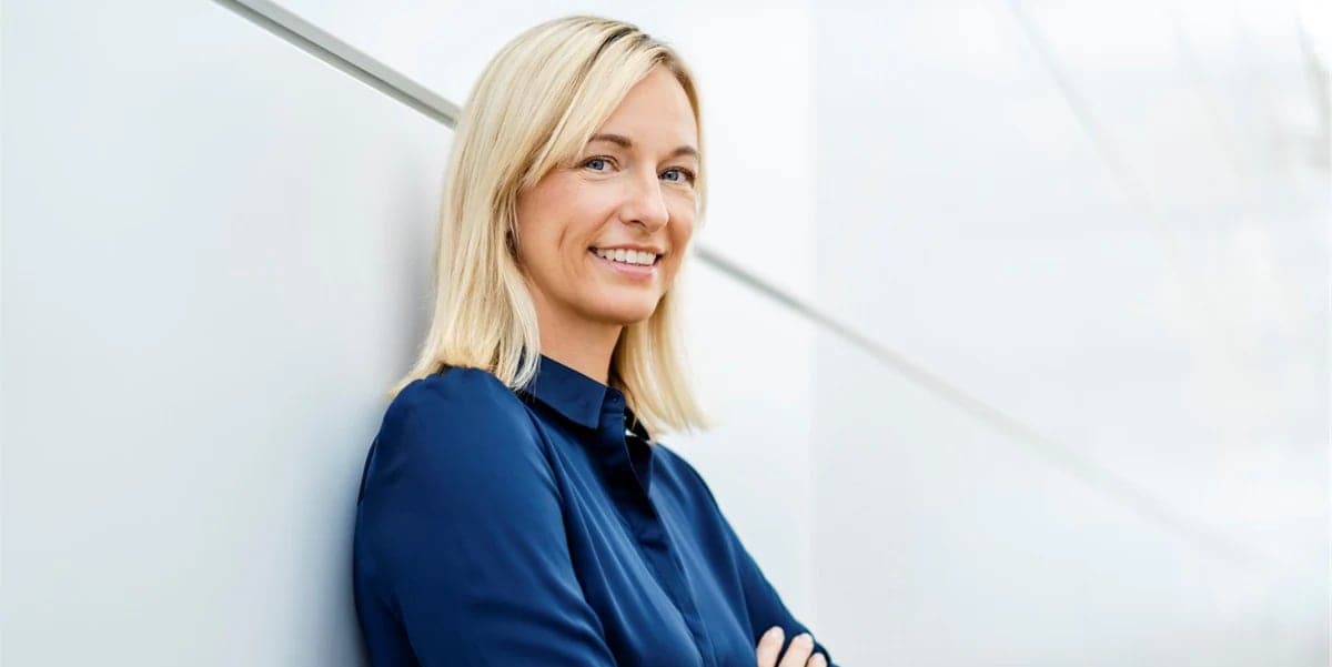 Blonde woman leaning against wall