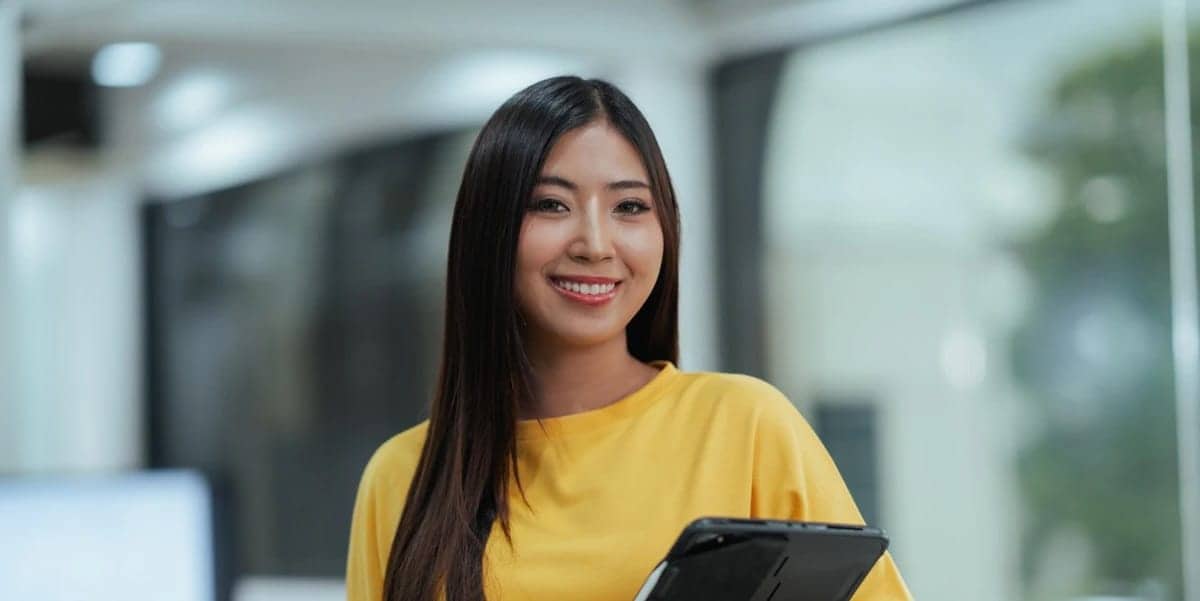 Woman in yellow shirt holding tablet