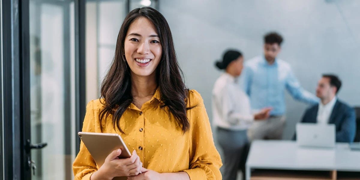 Woman in yellow shirt holding tablet