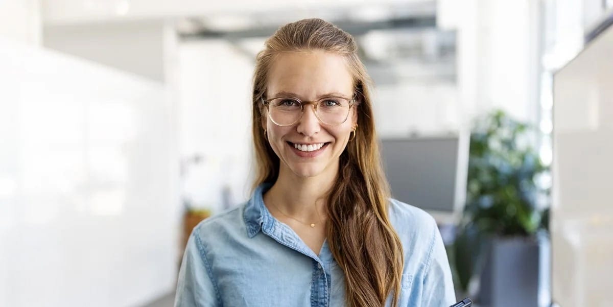 Woman with glasses smiles at camera