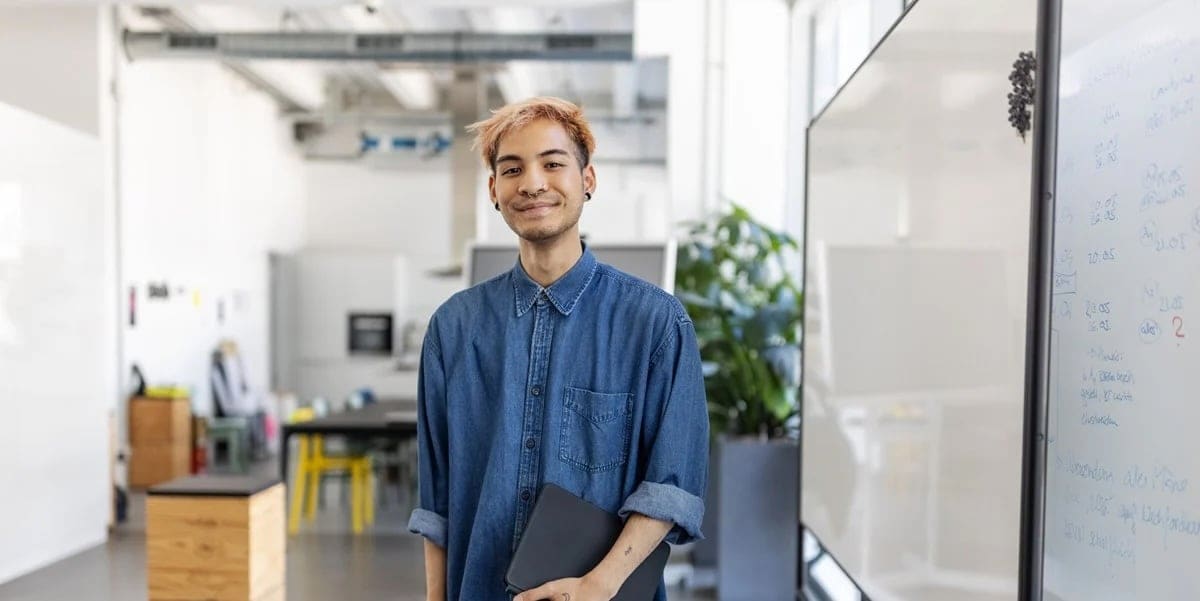 Man with dyed hair smiles at camera