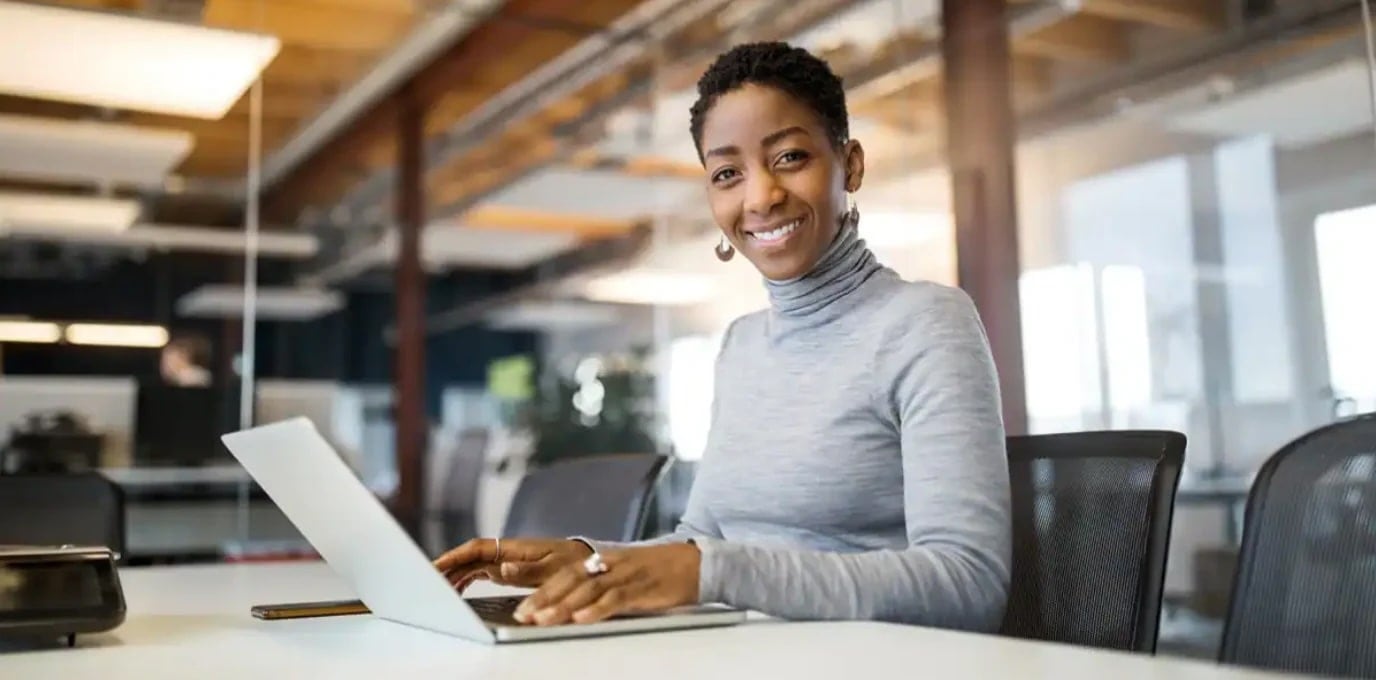Woman sitting at laptop, smiling