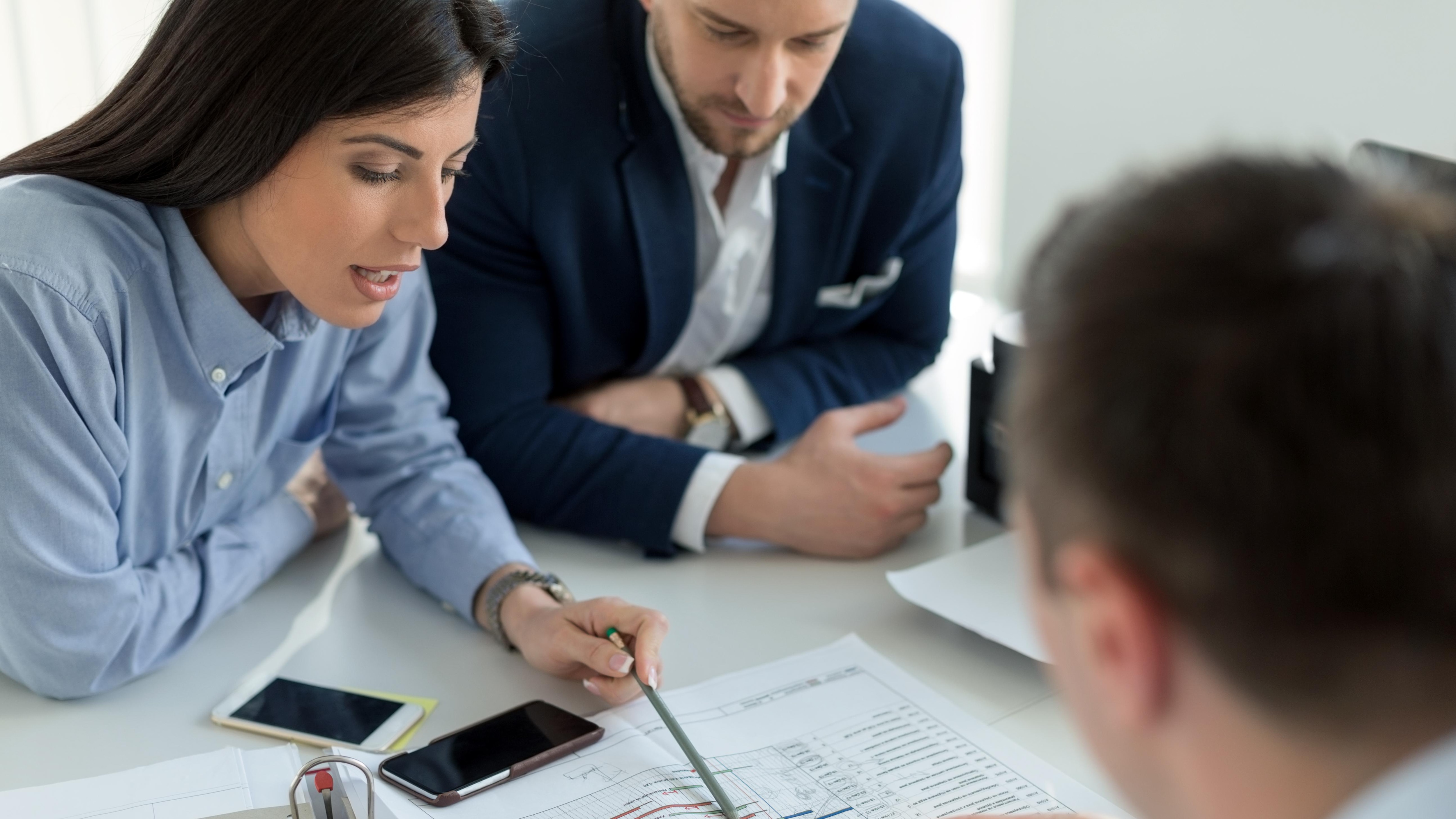 group of people look at papers at work