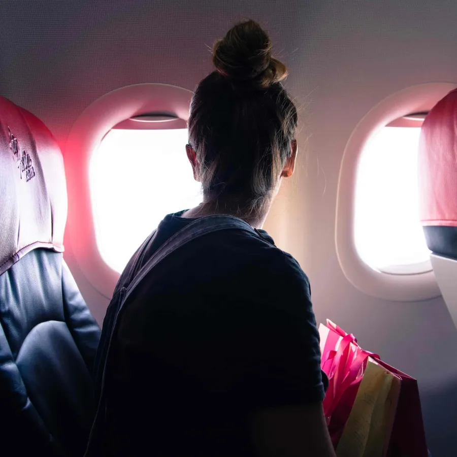 woman looking out plane window