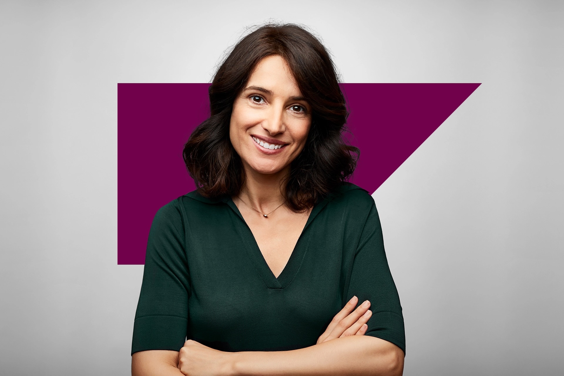 Woman smiling at camera in front of SAP Concur anvil logo