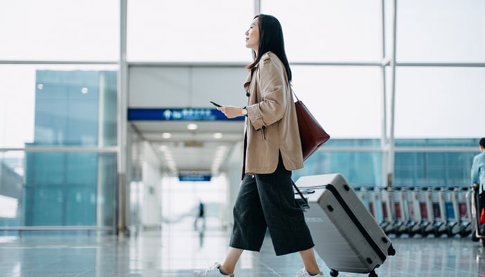 woman with luggage walking in airport