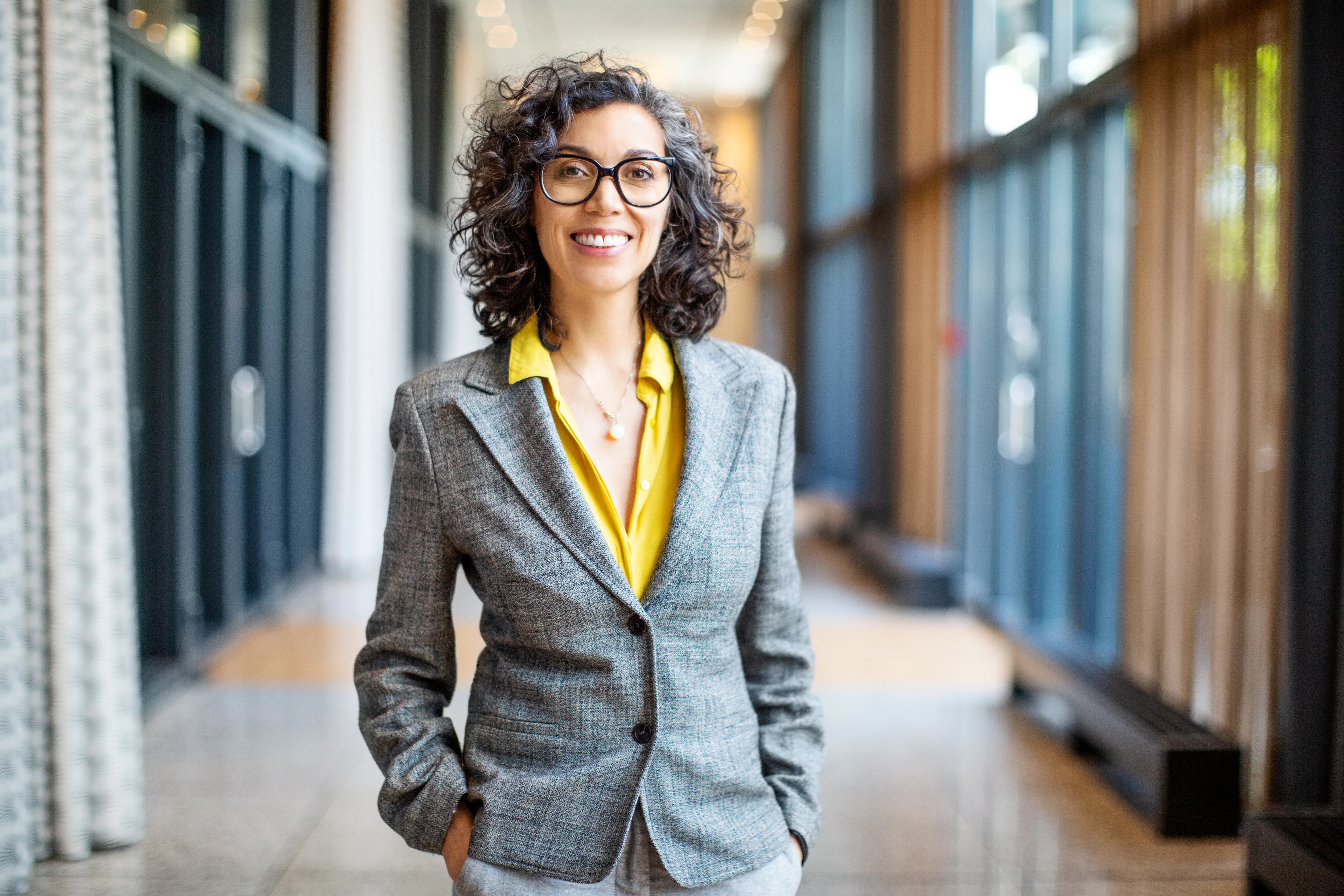 Woman in suit jacket smiling at camera