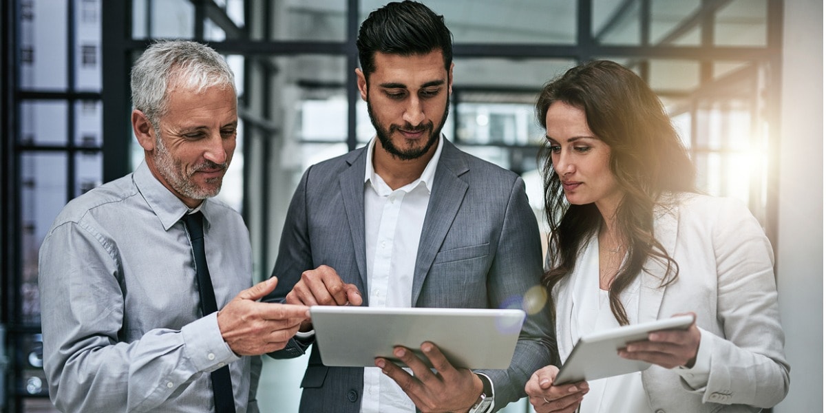 Two men and a woman looking at a tablet